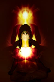 A woman meditates with a vibrant aura and light projections creating a spiritual ambience.